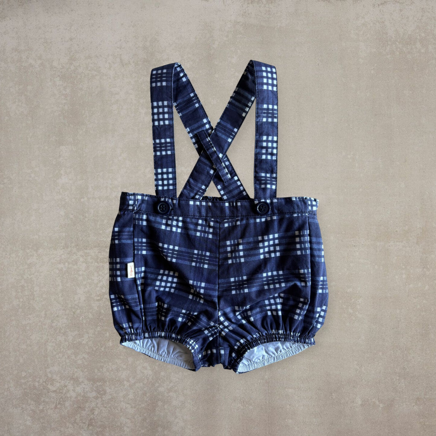 Pantalón corto con tirantes. Cuadros azules